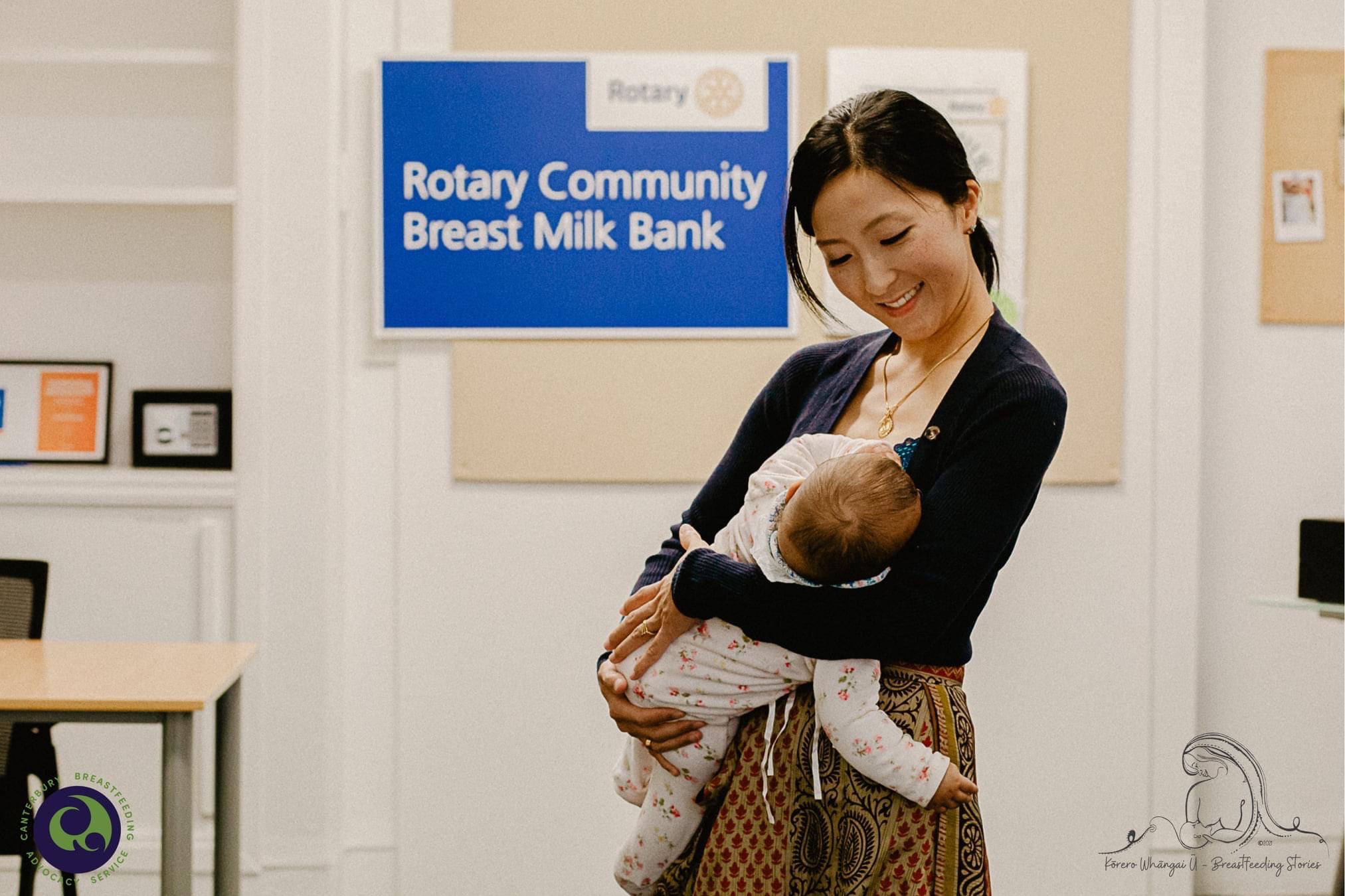 Woman standing holding baby.